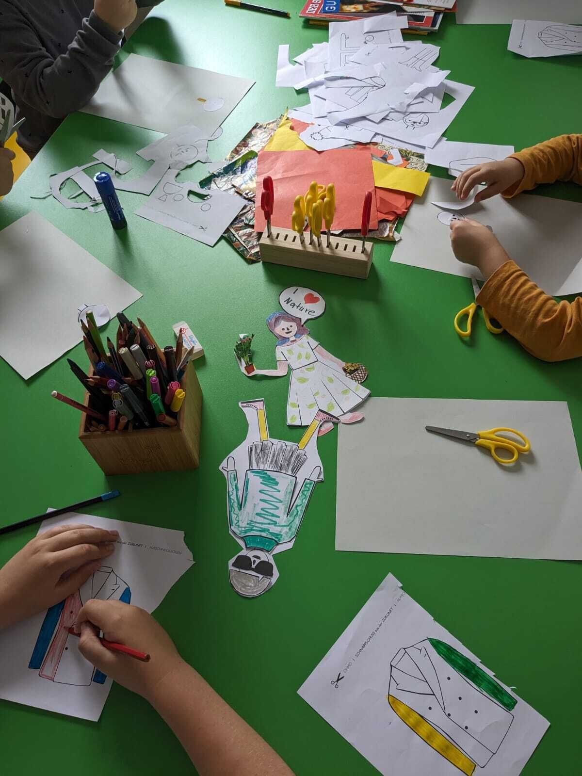 © SEB Leipzig Kinder schneiden Figuren aus Papier aus und bemalen Sie mit Stiften