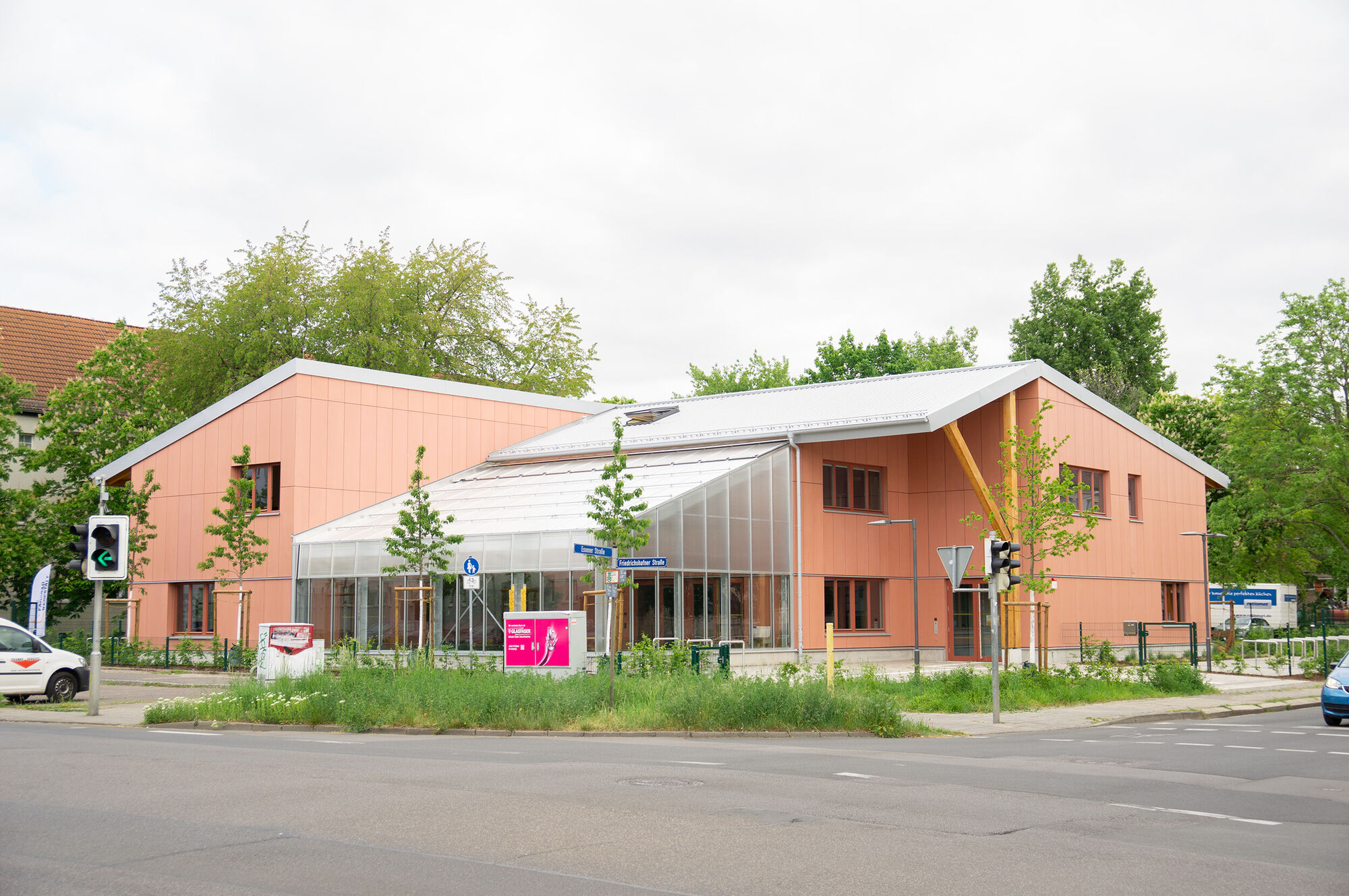 Ein großes Rotes Gebäude mit silbernem Dach und einem Glasvorbau.