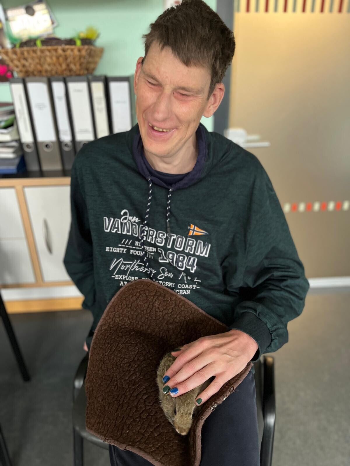 Ein Mann streichelt ein H&auml;schen auf einer Decke