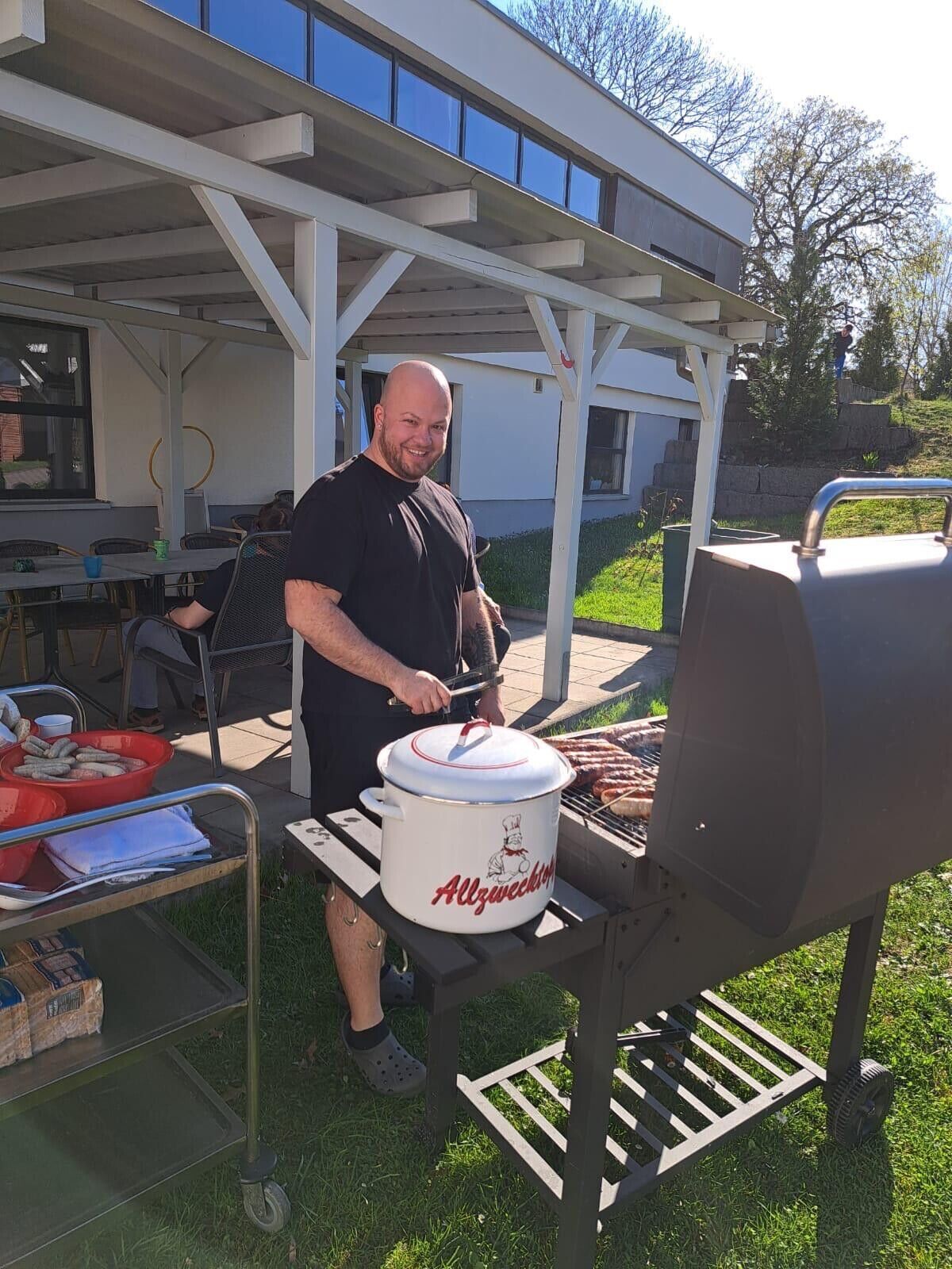© SEB Leipzig Ein Mann steht am Grill und lacht
