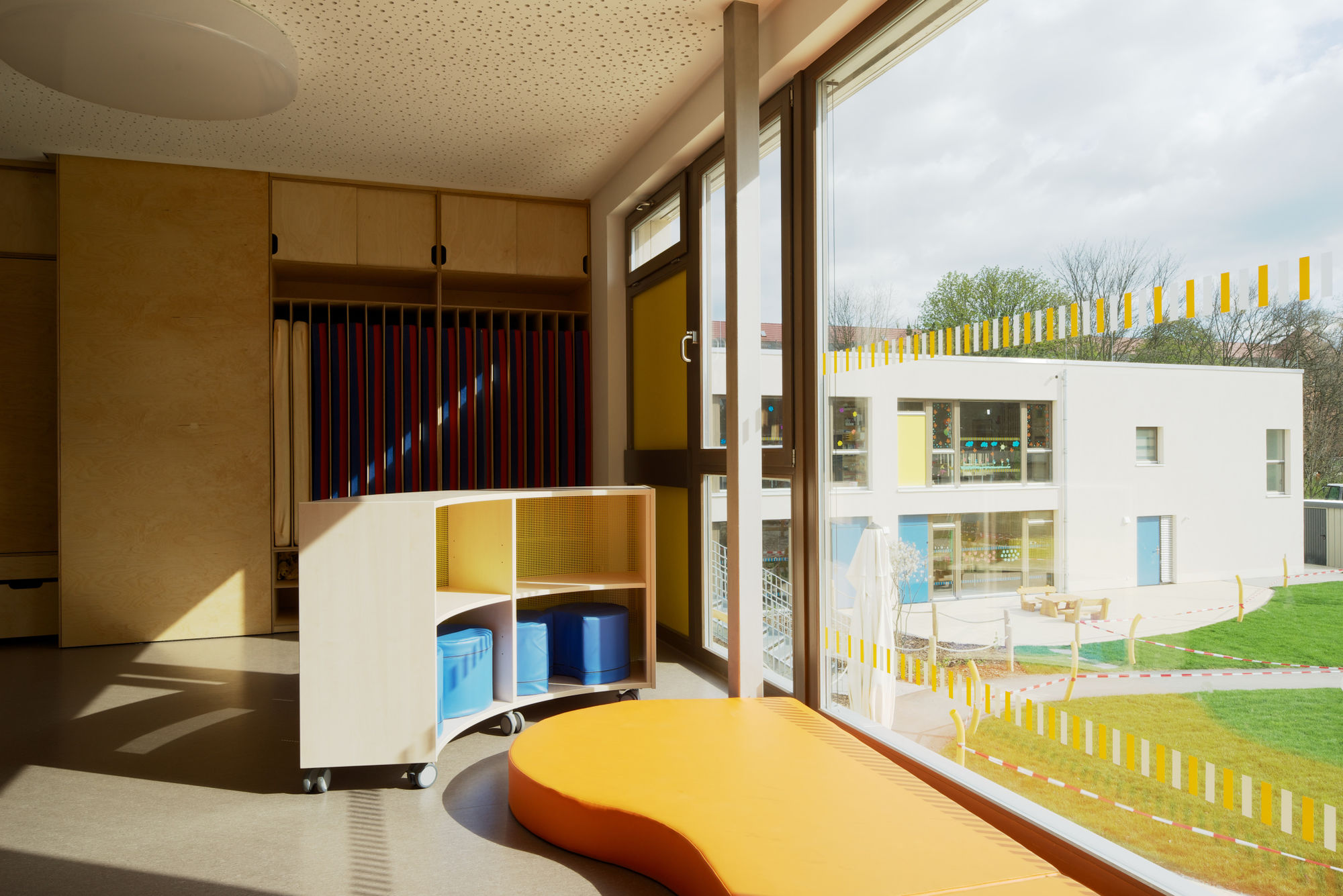 Ein Raum mit bodentiefem großen Fenster und Regalen.