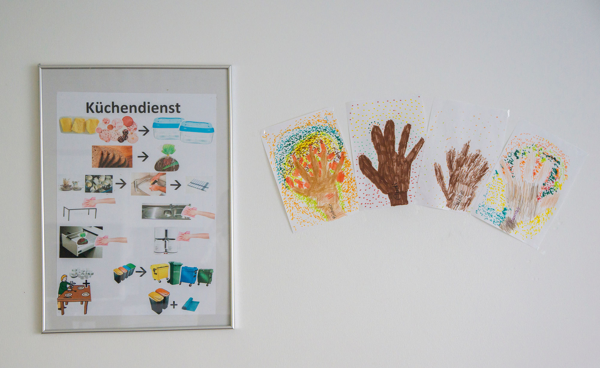an einer Wand hängen Bilder mit Hinweisen für den Küchendienst