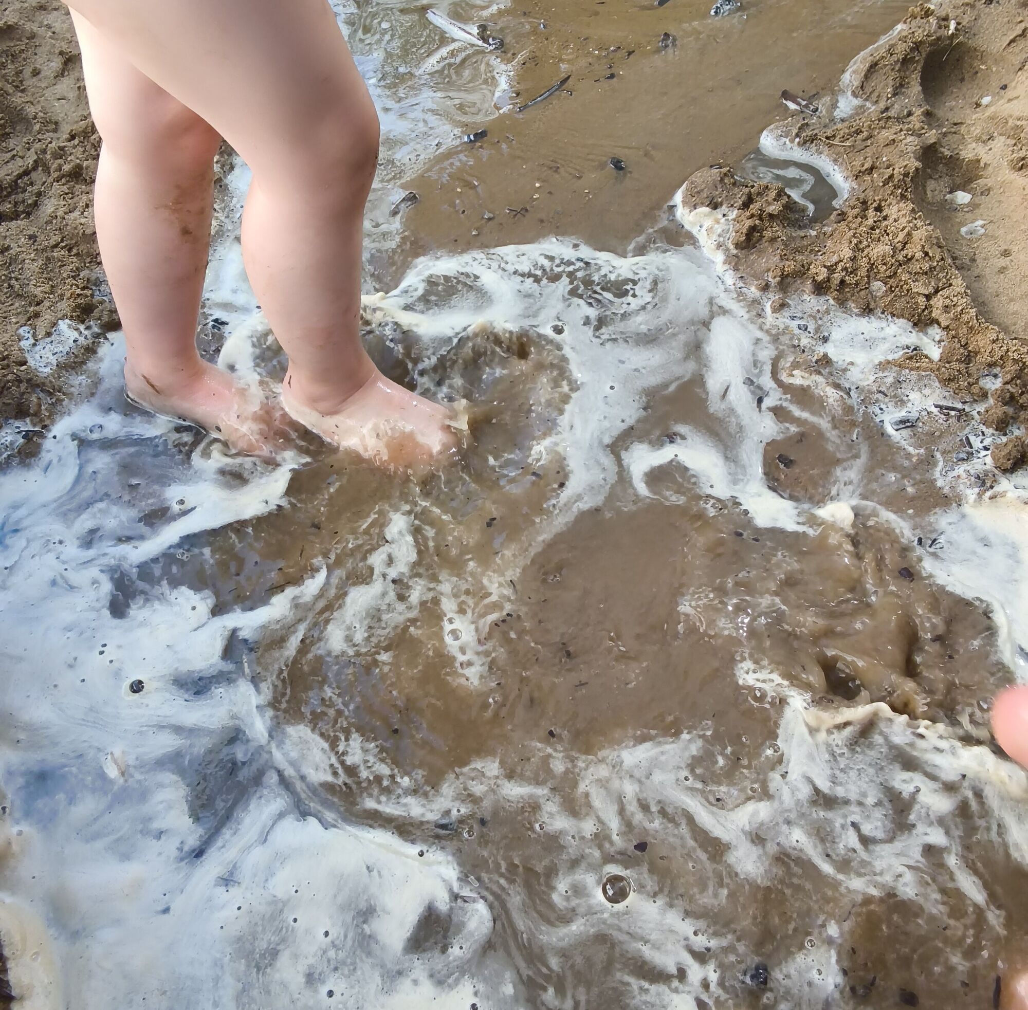 Kinderf&uuml;&szlig;e im matschigen Sand
