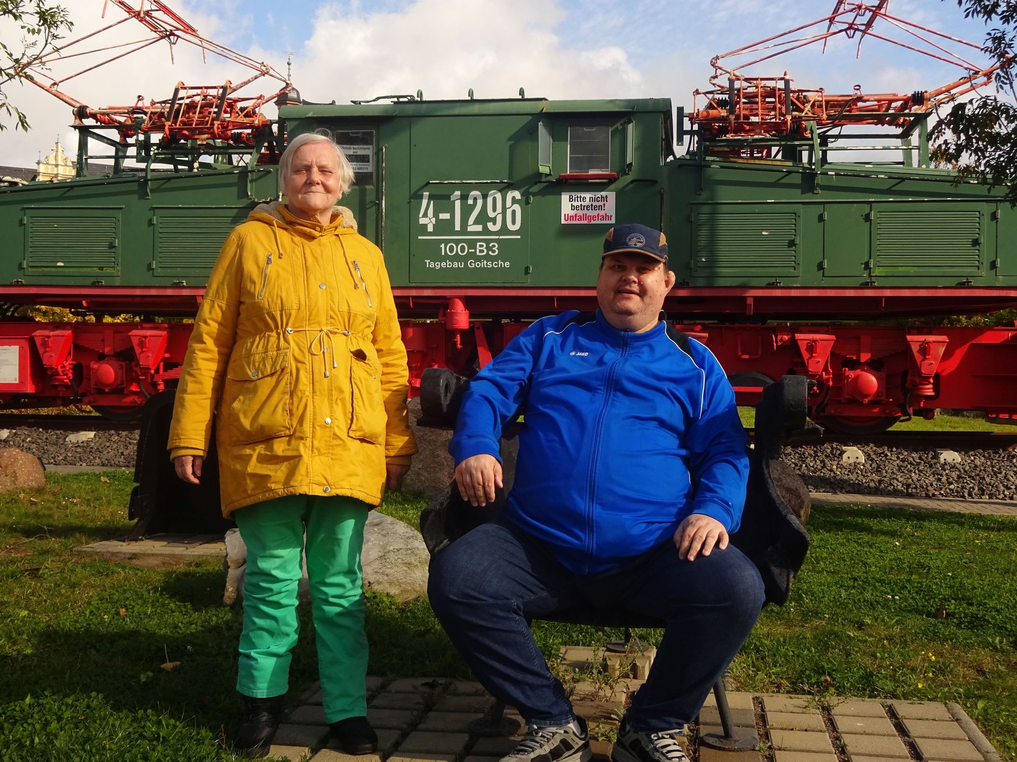 Zwei Menschen stehen vor einer historischen Eisenbahn.