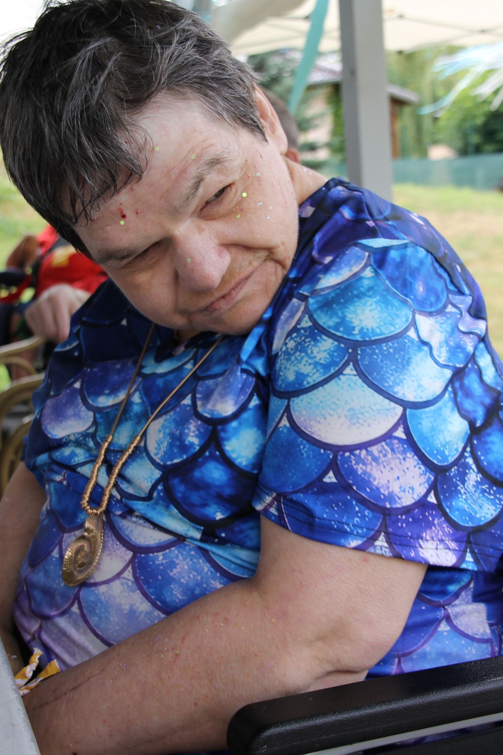 ein Frau mit Schuppen-T-Shirt und Meereskette