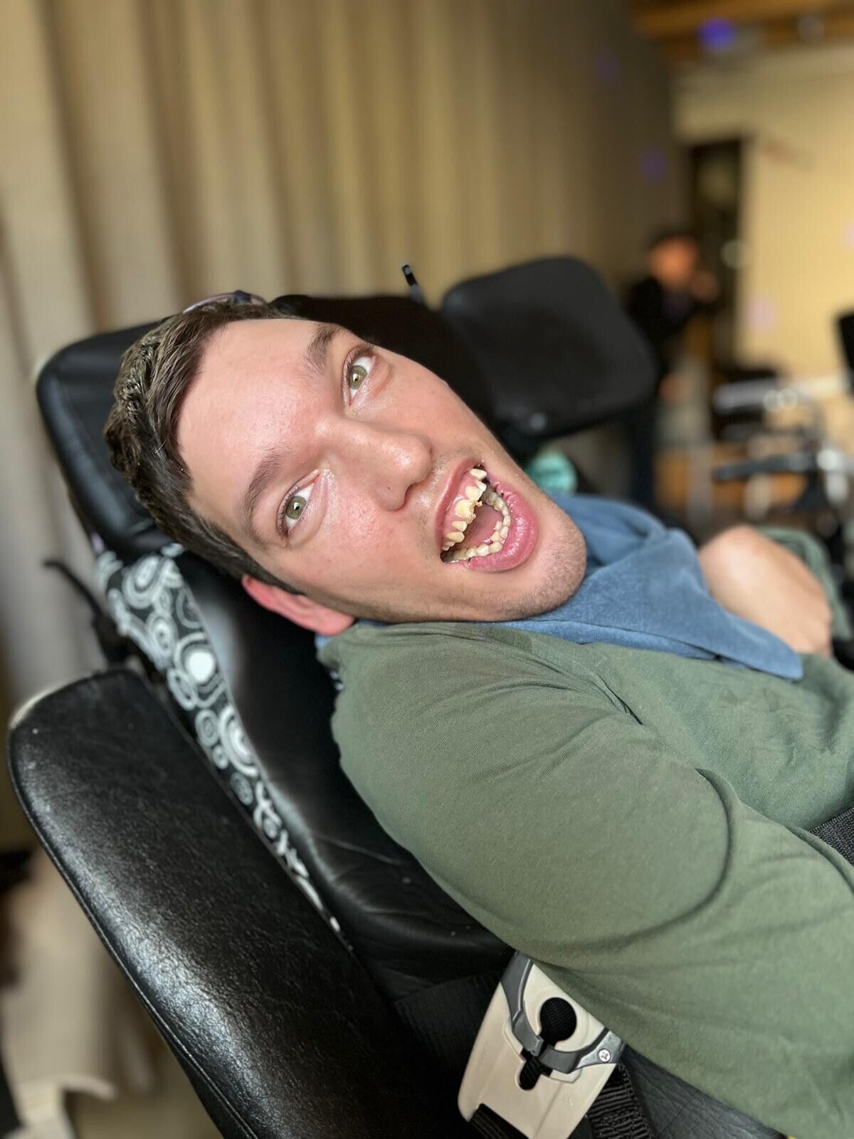 Ein Mann im Rollstuhl lacht in die Kamera