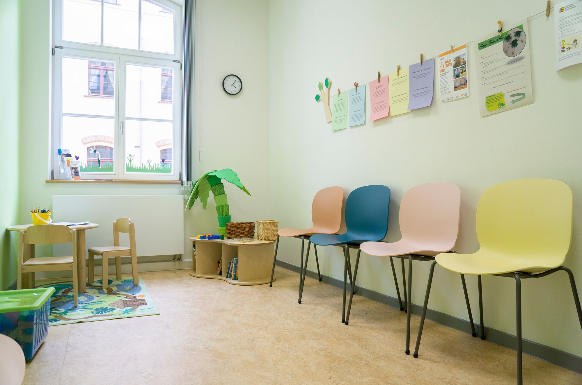 Ein heller Raum mit Stühlen und Spielecken  für Kinder