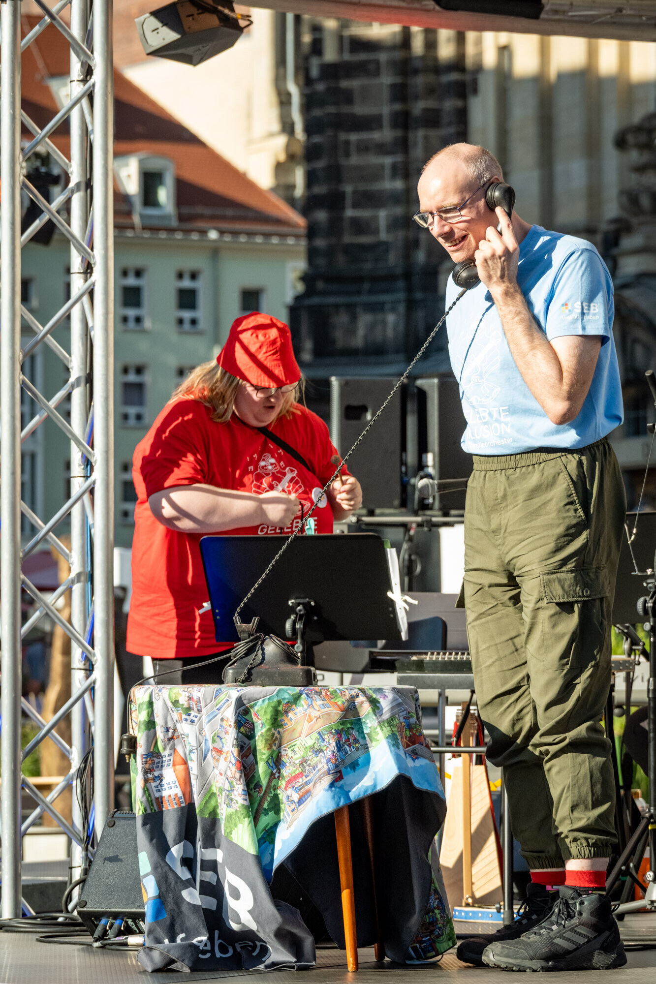 Ein Ensemble-Mitglied auf der B&uuml;hne mit Telefonh&ouml;rer am Ohr