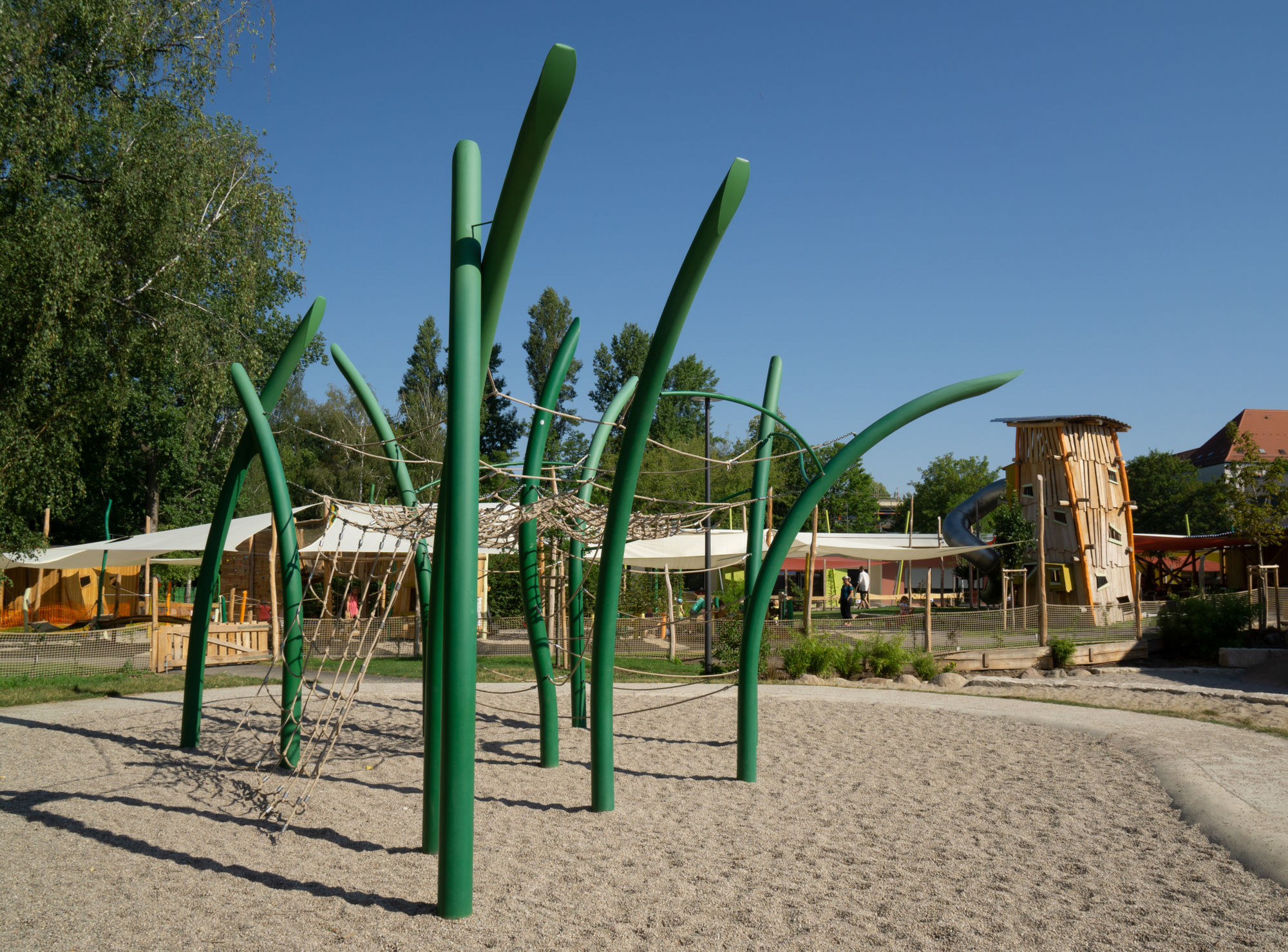 Ein großes Klettergerüst mit grünen Holzpfeilern und Netzen.