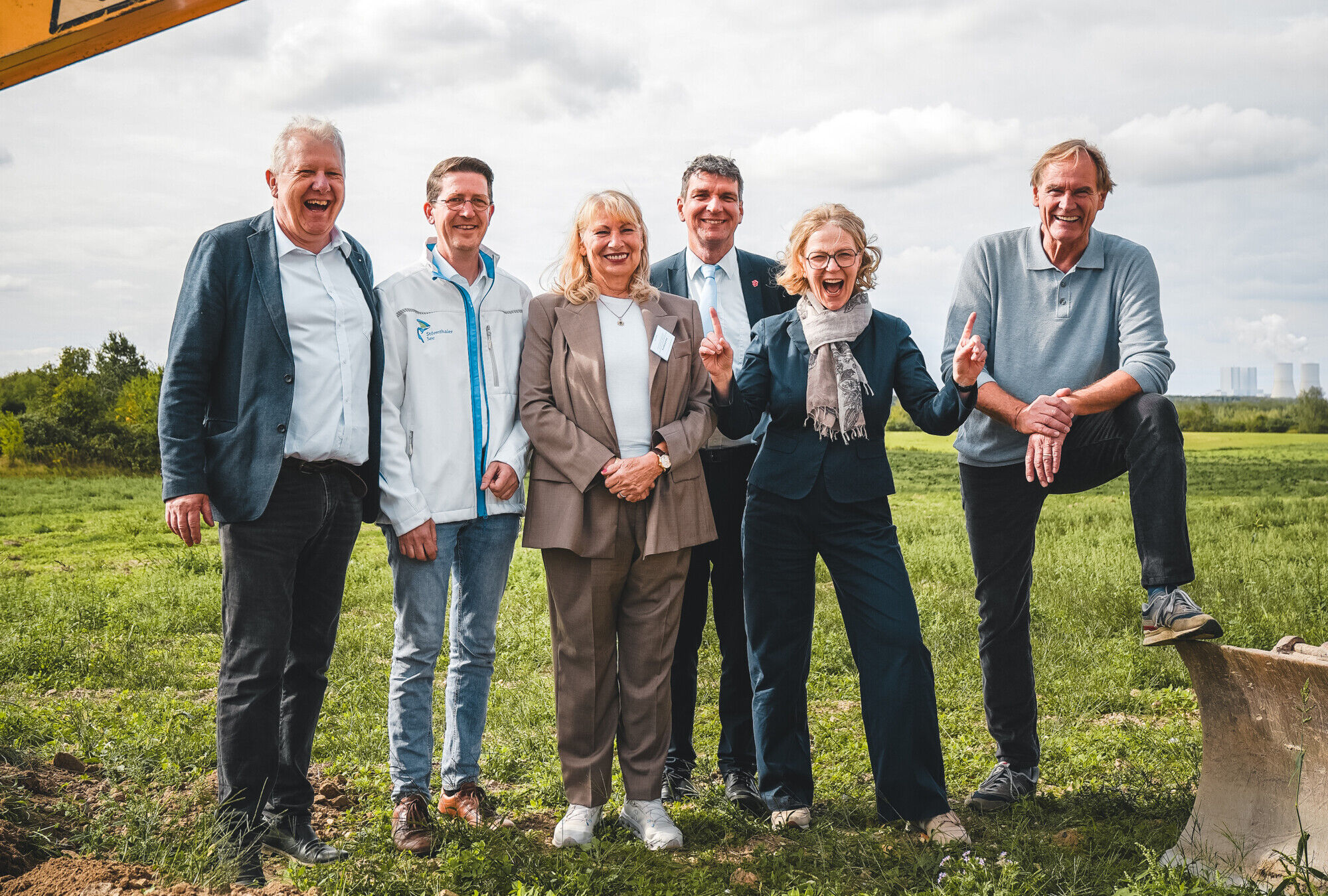 Die Talkg&auml;ste stehen am Bagger und freuen sich ausgelassen