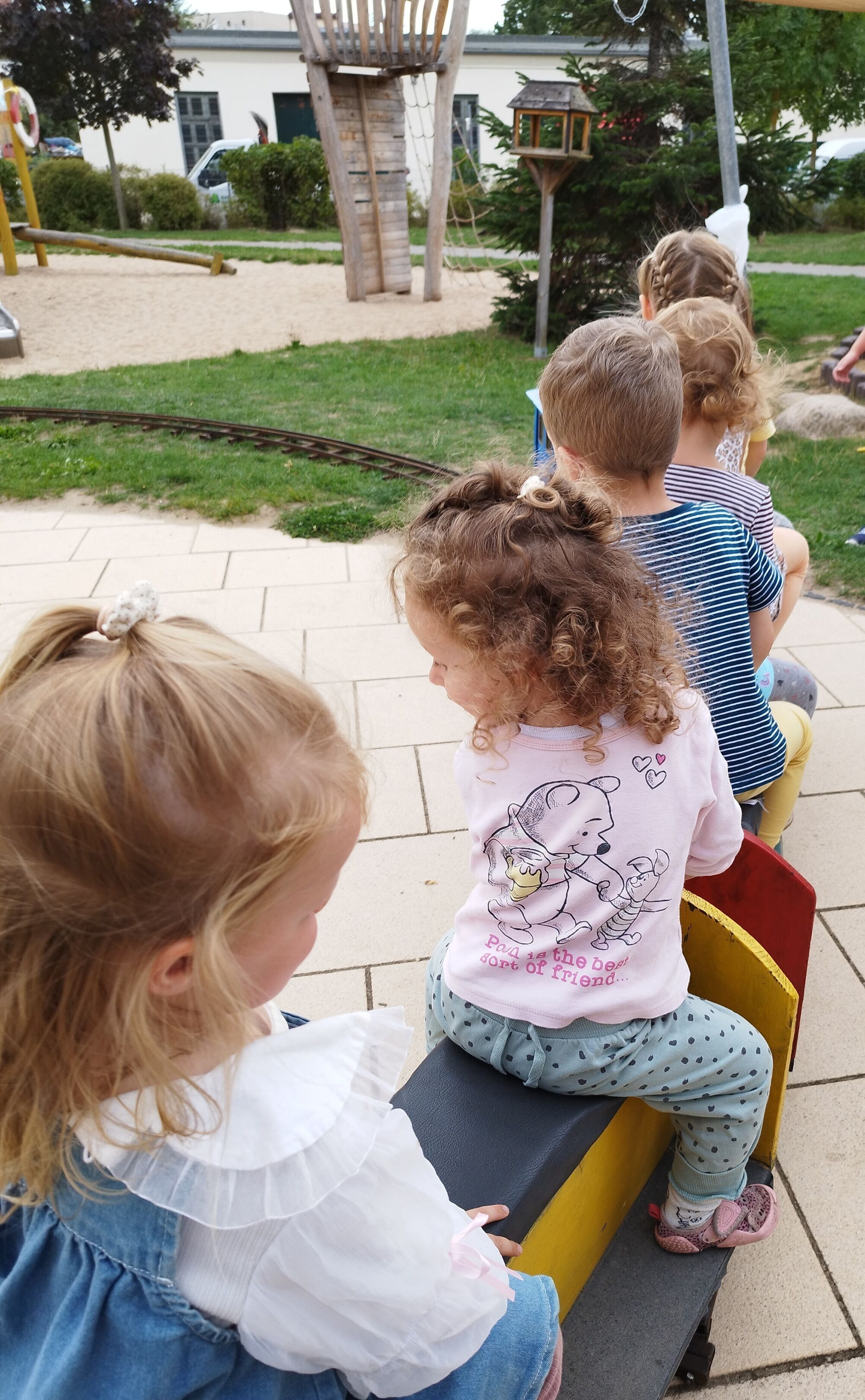 Kinder sitzen auf den Wagons und werden von der Lokomotive gezogen