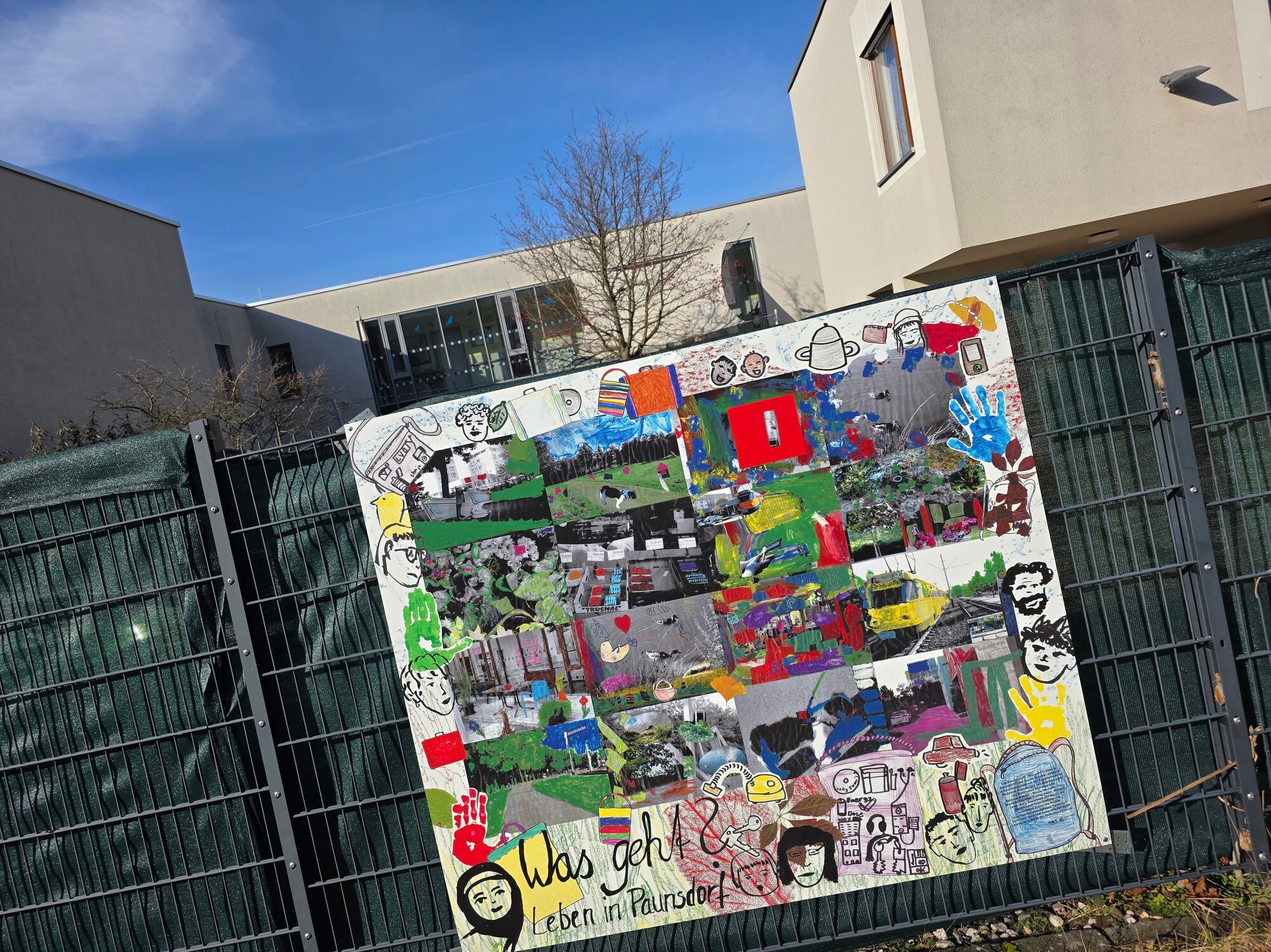 Eine bunte Collage h&auml;ngt an einem Zaun