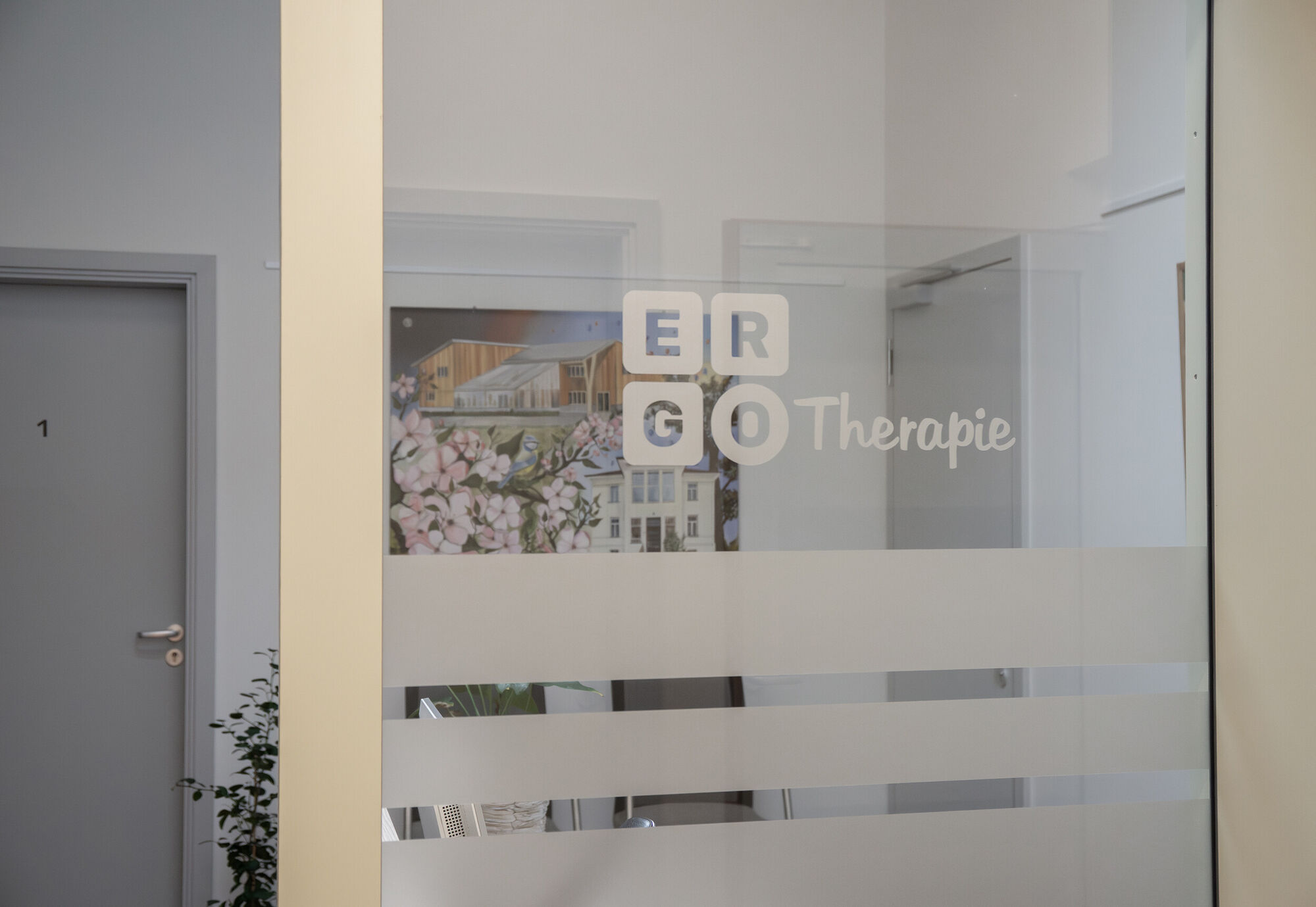 eine Glastür mit dem Logoaufdruck Ergotherapie