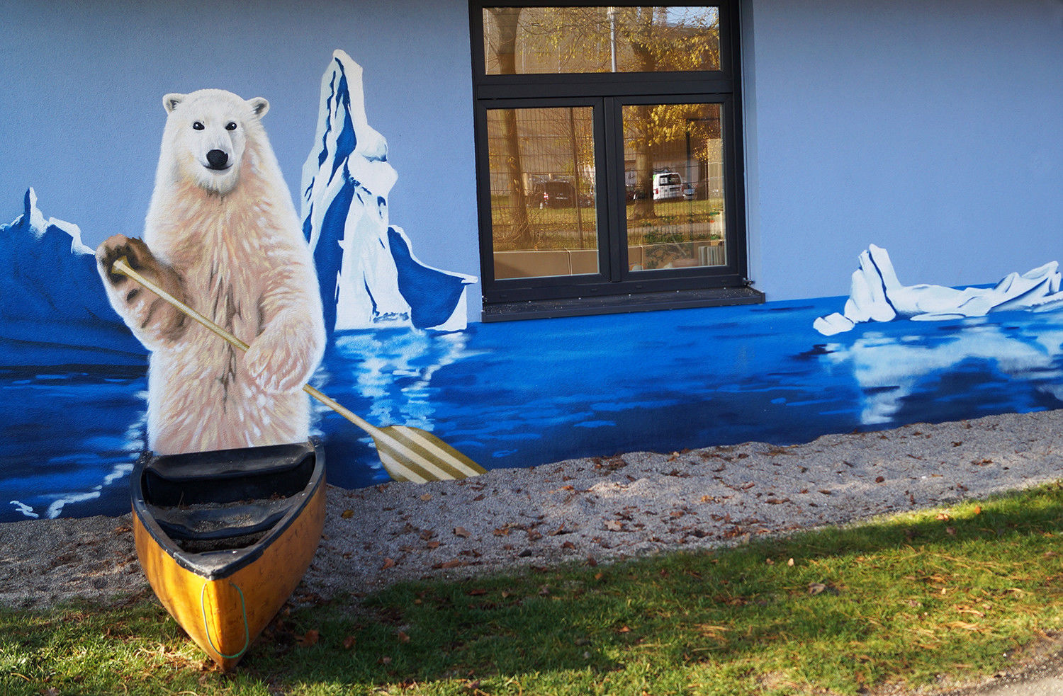Eine Außenfassade bemalt mit einem Eisbären, Wasser und Eisbergen.