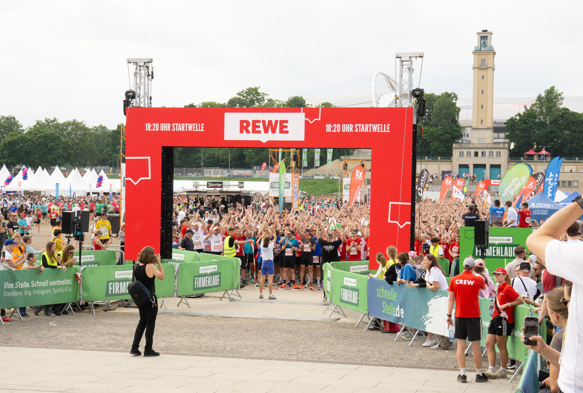 Viele Menschen strecken die H&auml;nde in die H&ouml;he und warten auf den Startschuss zum Lauf