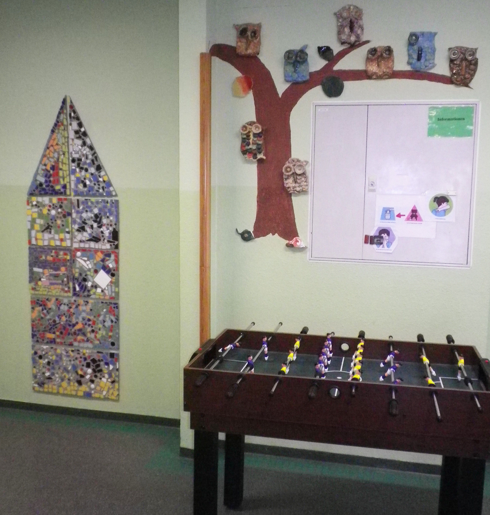 Ein Tischkicker steht vor einer dekorierten Wand.