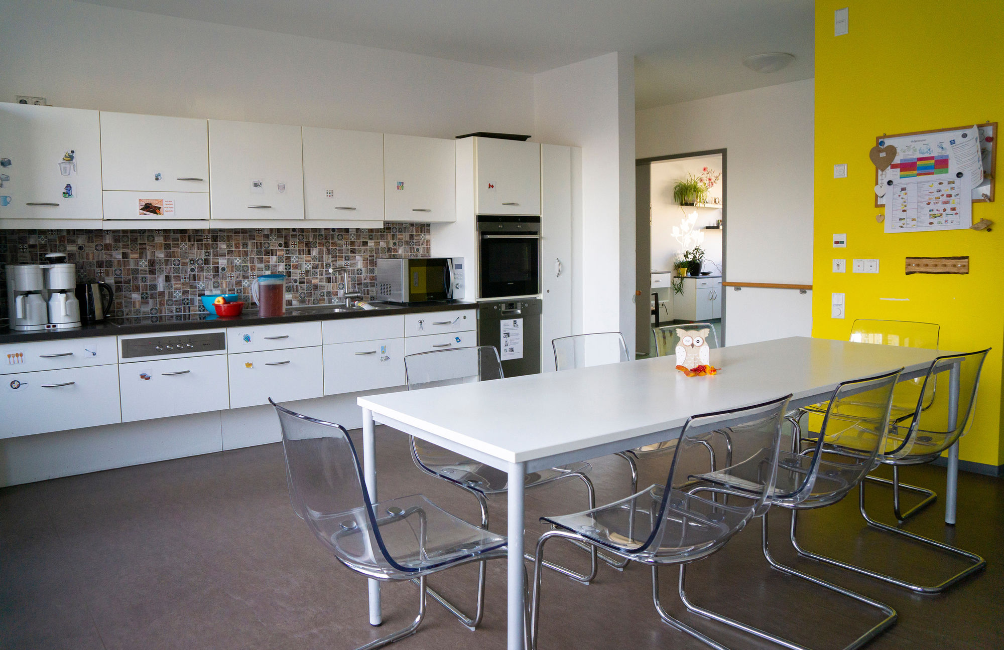 Ein Gemeinschaftsraum mit Küchenzeile, Tisch und Stühlen.