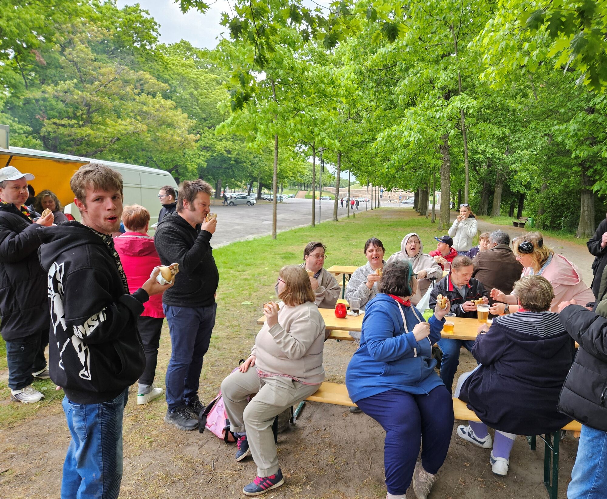 © SEB Leipzig Menschen sitzen auf Bänken in einem Park und Essen
