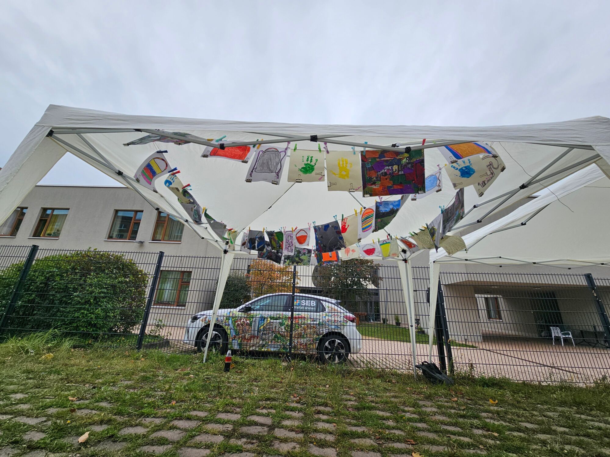 Viele Kunstwerke sind unter einem Pavillon an einer Schnur aufgespannt