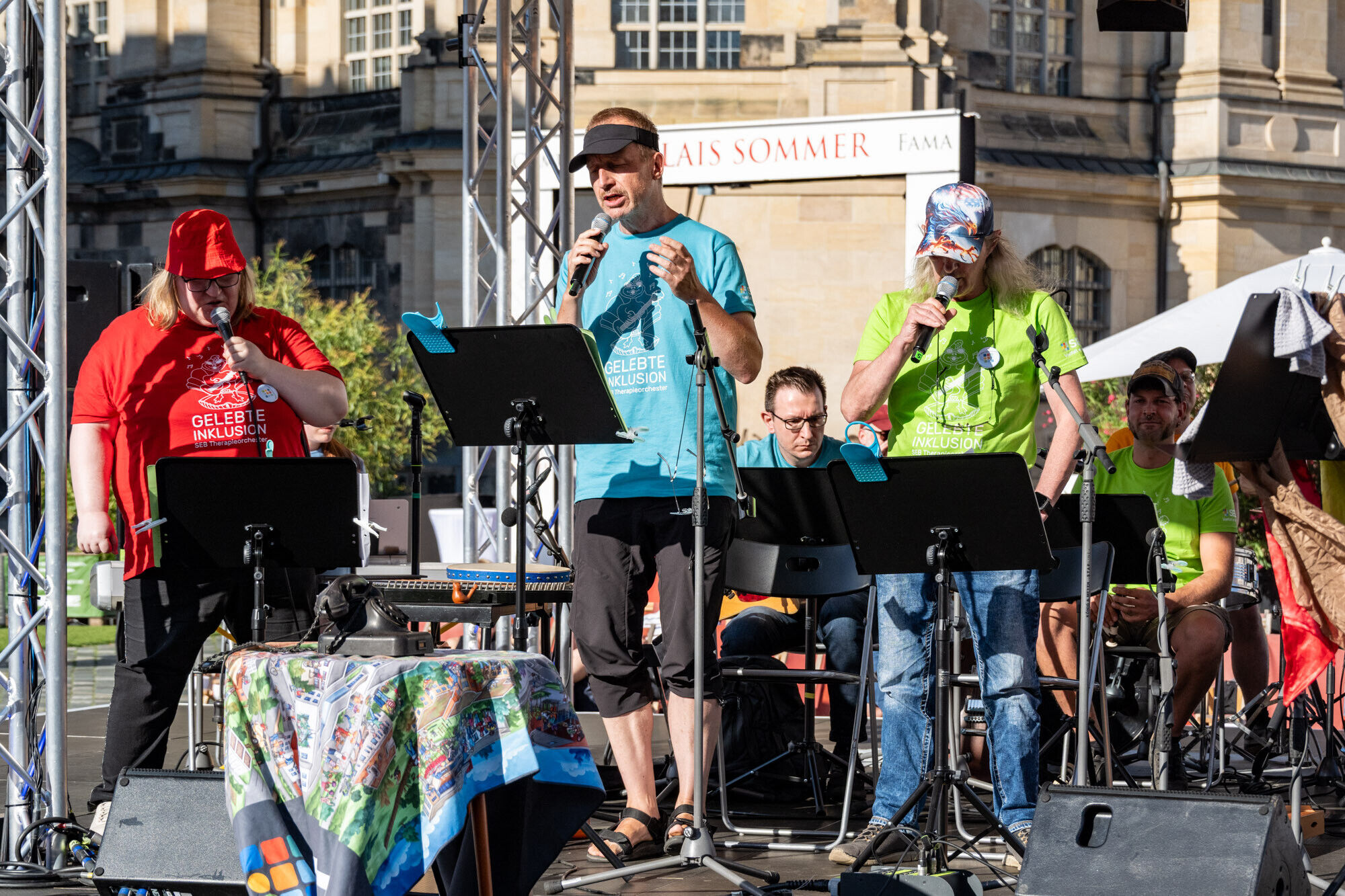 Enseble-Mitglieder auf der B&uuml;hne mit Mikrofon