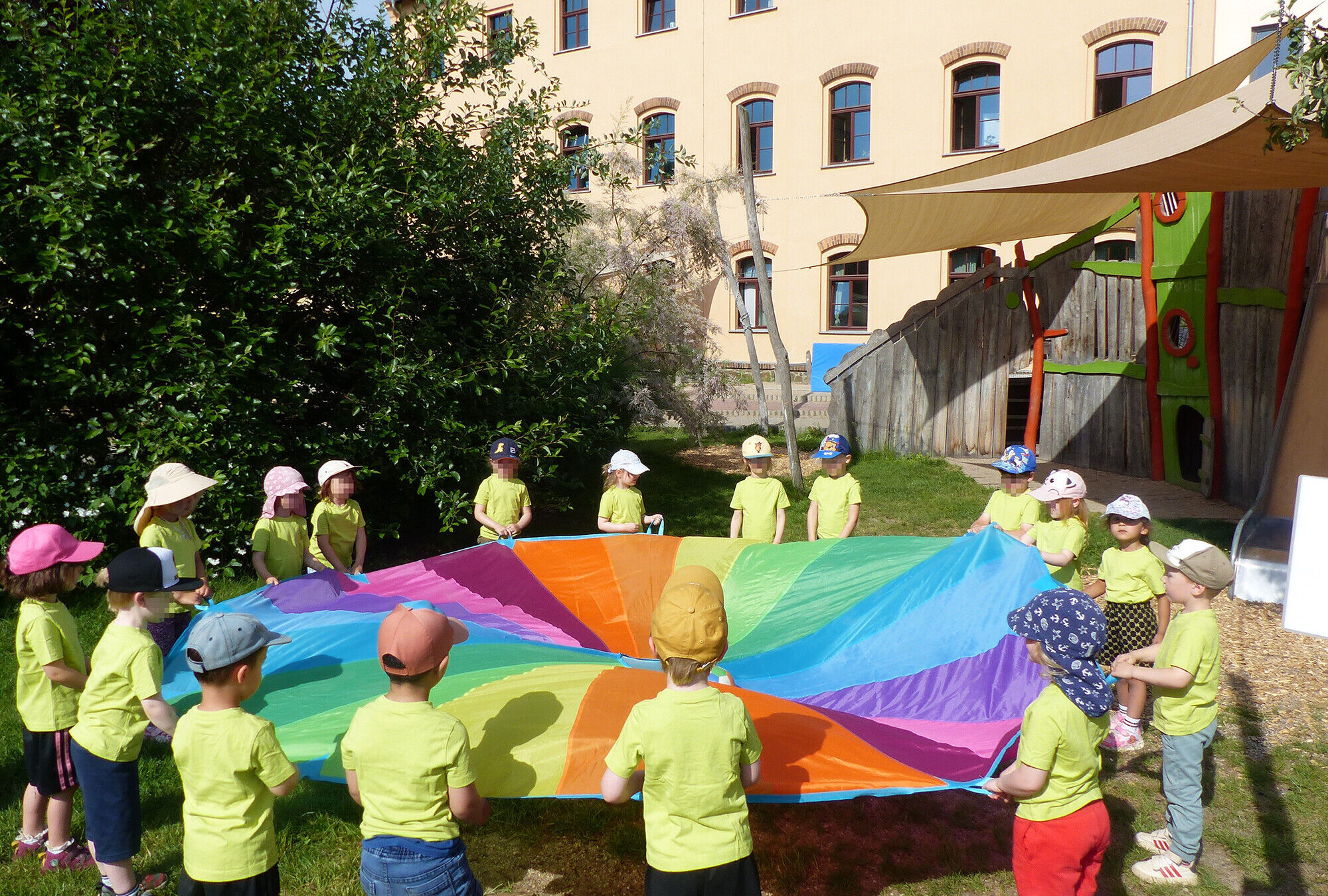 Viele Kinder halten ein buntes Schwungtuch
