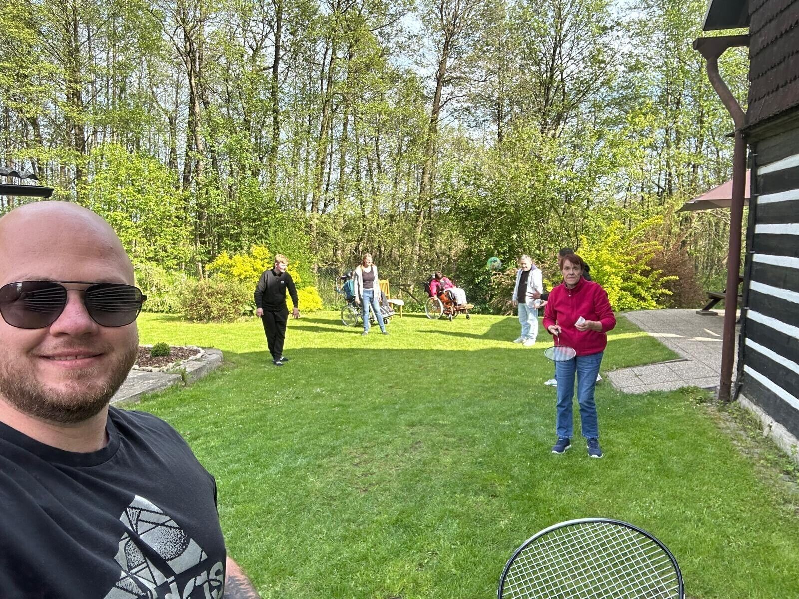 © SEB Leipzig Viele Menschen in einem grünen Garten. Sie haben Federballschläger in der Hand.
