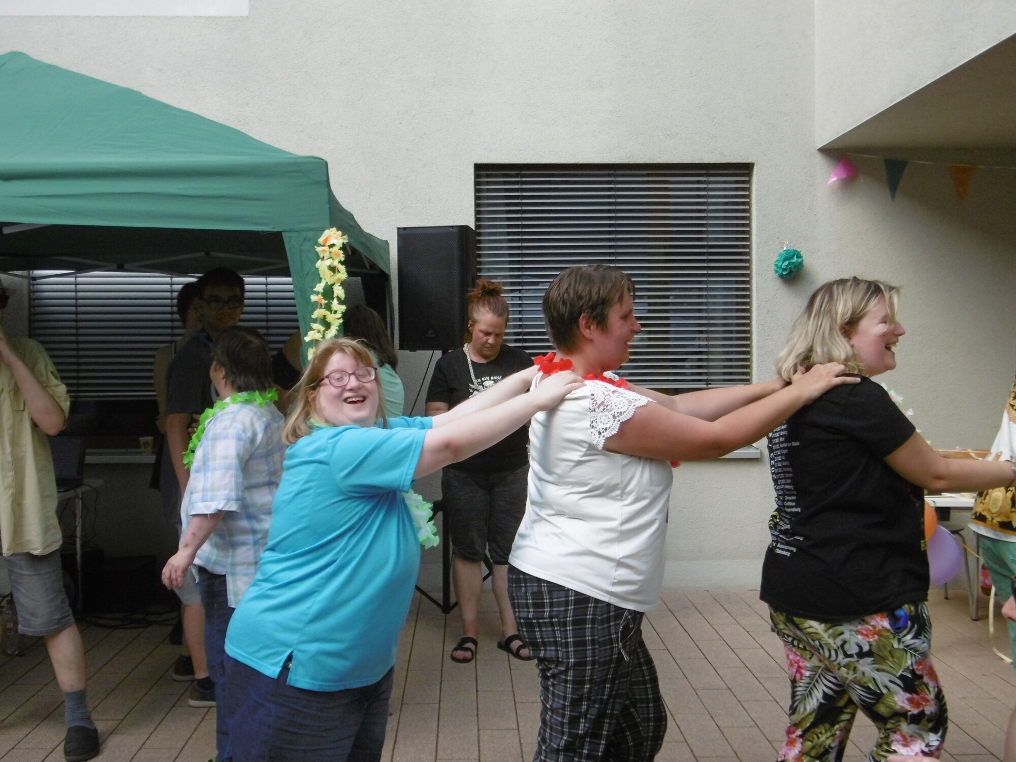 Menschen fassen sich für eine Polonaise an den Schultern und lachen