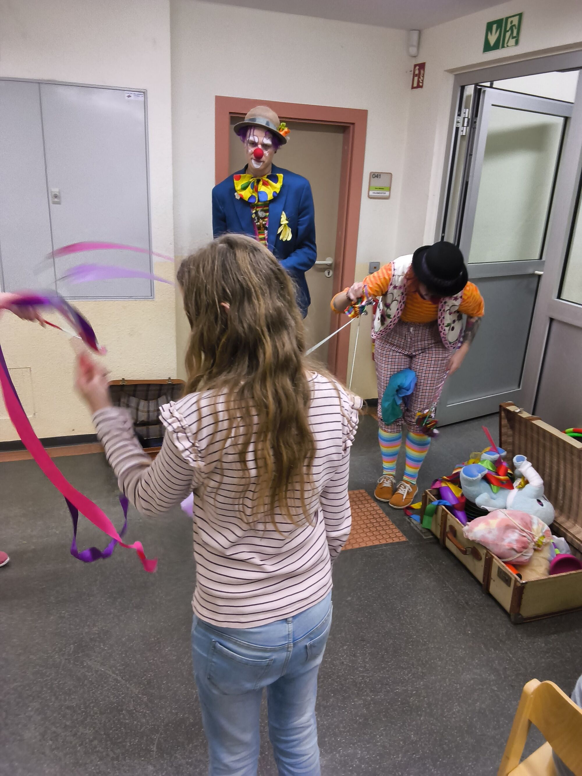 Zwei Clowns und ein M&auml;dchen Schwingen Gymnastikb&auml;nder mit Stab