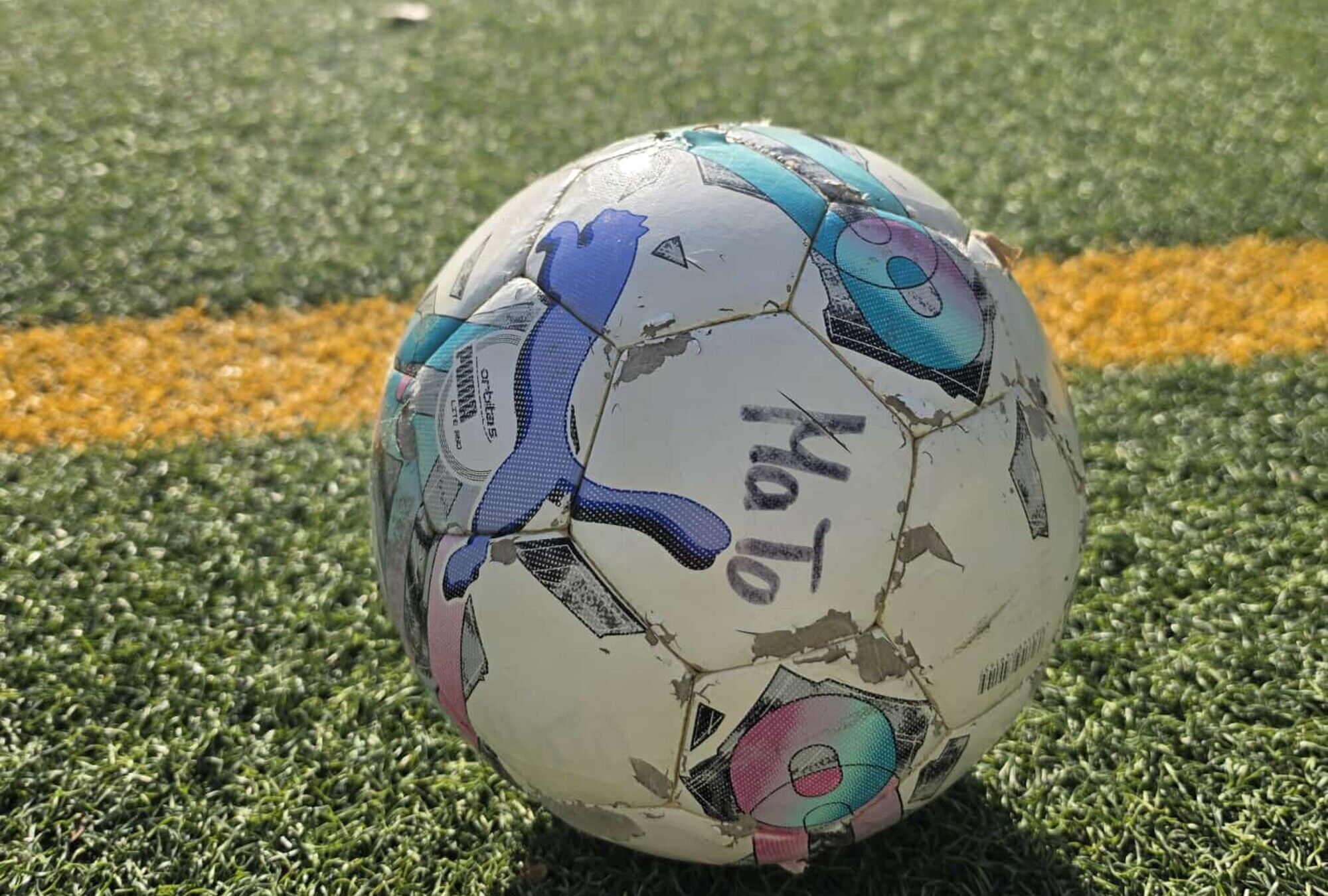 Ein Fussball auf einem Kunstrasenplatz