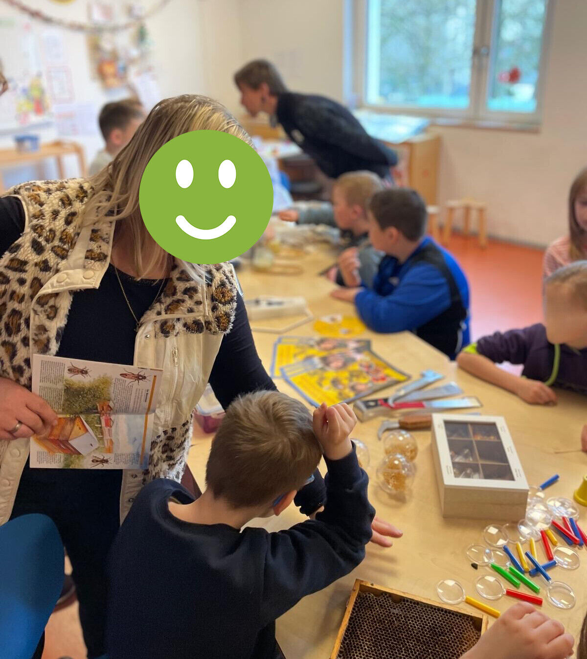 Kinder sitzen an einem Tisch mit viel Anschauungsmaterial
