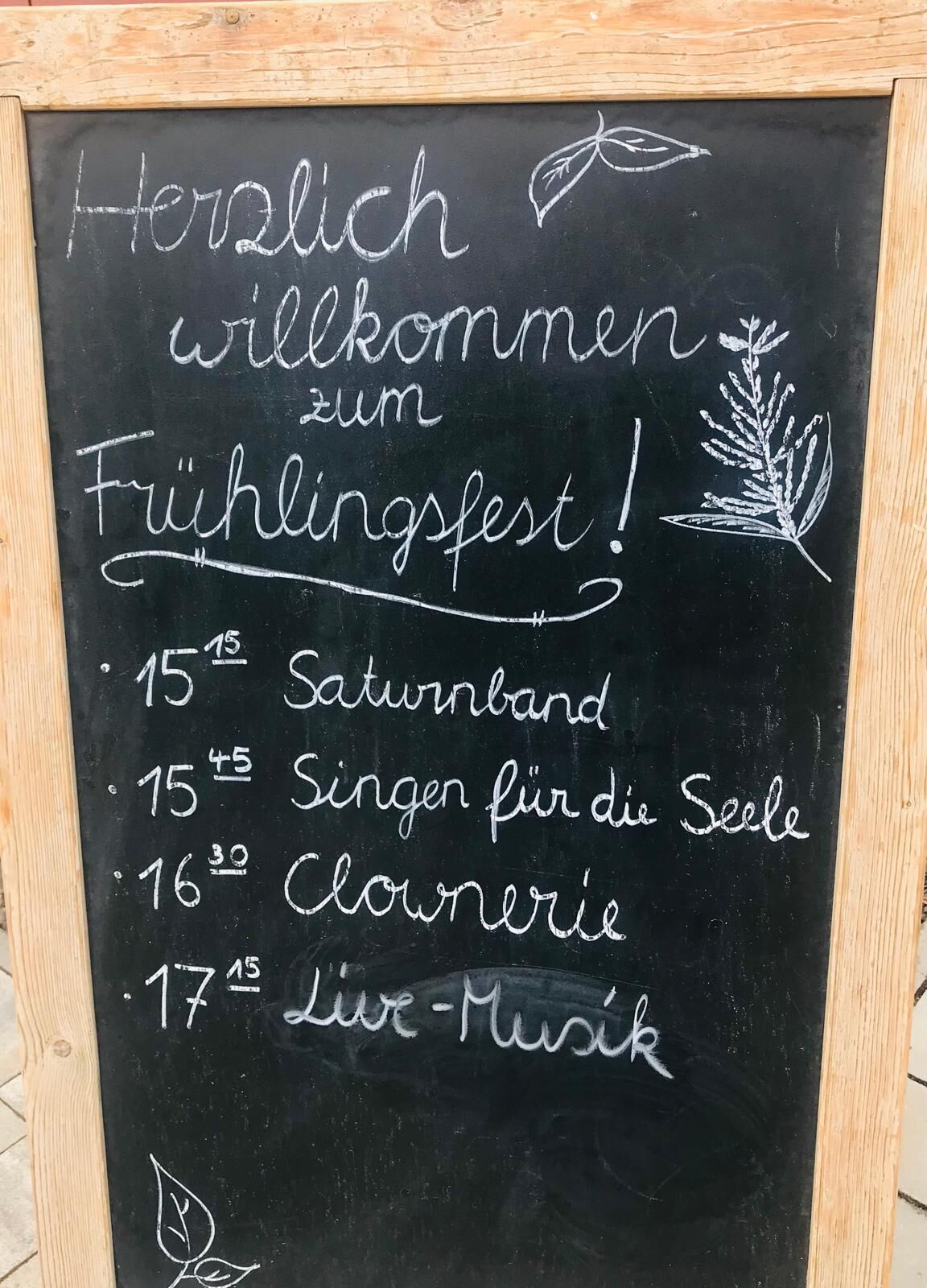 Eine Tafel mit dem Programm zum Fest (Saturnband, Singen f&uuml;r die Seele, Clownerie, Live-Musik)