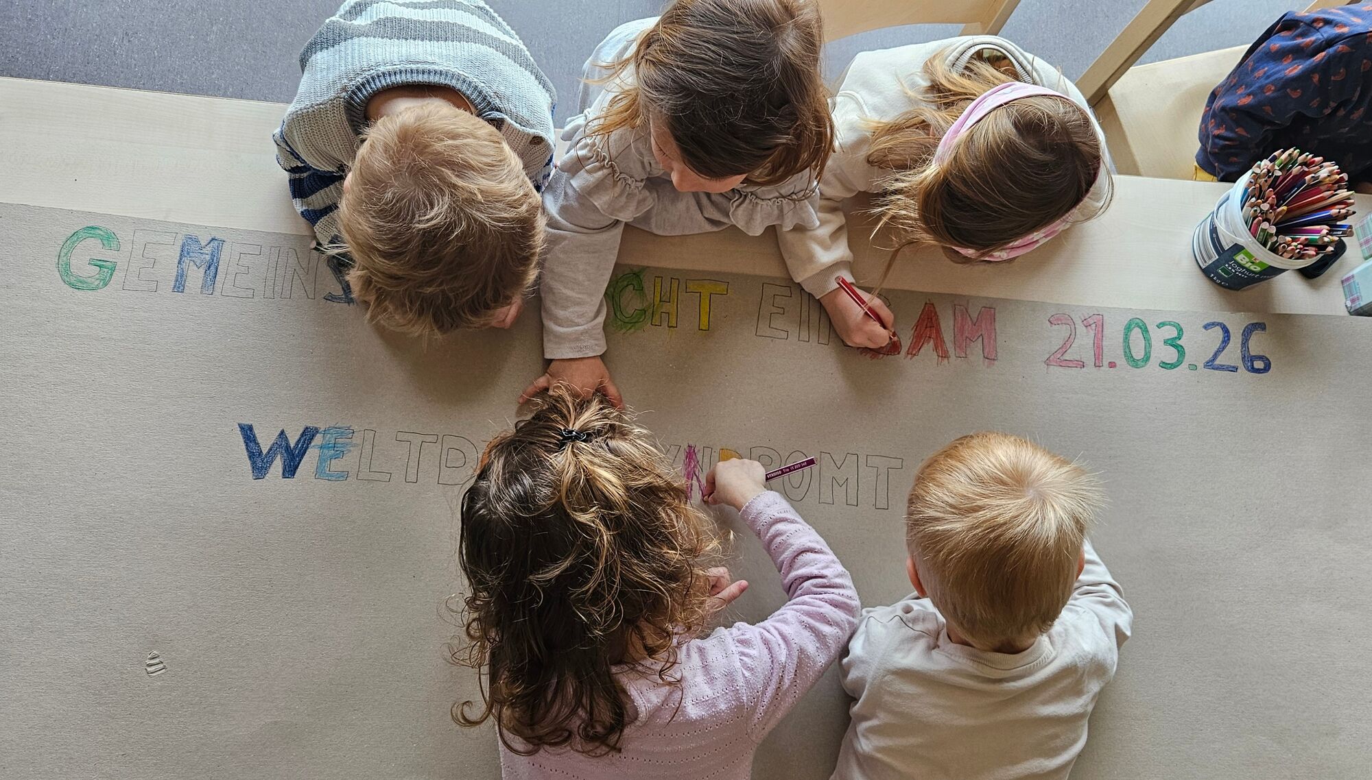 Kinder malen vorgezeichnete Buchstaben aus